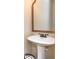 Contemporary powder room with a pedestal sink, framed mirror, and under-sink storage basket at 516 Black Horse Cir, Canton, GA 30114