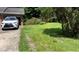 A view of the driveway, featuring green grass and a white Lexus at 6521 Menlo Way, Rex, GA 30273