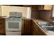 A practical kitchen featuring a stove, double sink, and wooden cabinets, offering functionality at 6521 Menlo Way, Rex, GA 30273