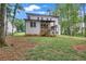Expansive backyard with lush green grass, a wooden deck, and mature trees, perfect for outdoor activities at 104 Woodland Ln, Canton, GA 30114