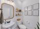 Stylish half bathroom with a decorative mirror, floating shelves, and elegant fixtures at 104 Woodland Ln, Canton, GA 30114
