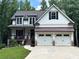 Beautifully landscaped craftsman-style home with a two-car garage and inviting covered porch at 104 Woodland Ln, Canton, GA 30114