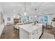 Bright open-concept living room featuring a stone fireplace, hardwood floors, and stylish kitchen island with modern light fixtures at 104 Woodland Ln, Canton, GA 30114