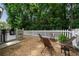 A cozy backyard with a white picket fence, gravel, stylish patio chairs, and a deck with a grill at 1360 Edmund Ne Ct, Atlanta, GA 30306