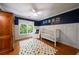 Charming Bedroom with blue walls, white wainscoting, a crib, and a colorful rug creating a cozy and inviting space at 1360 Edmund Ne Ct, Atlanta, GA 30306