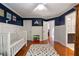 Charming Bedroom with blue accent walls, white wainscoting, a crib, and hardwood floors creating a comforting space at 1360 Edmund Ne Ct, Atlanta, GA 30306