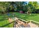 Aerial view of a large backyard featuring a deck, patio, playhouse, trampoline, storage shed, and play set at 151 Quail Hollow Dr, Dallas, GA 30157