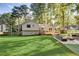The beautiful backyard features a well-maintained lawn, mature trees, a deck, and an outdoor seating area at 151 Quail Hollow Dr, Dallas, GA 30157