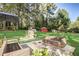 A vast backyard with lush lawn, mature trees, play equipment, and a patio area with comfortable wicker furniture at 151 Quail Hollow Dr, Dallas, GA 30157