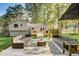 Backyard with a custom patio with ample seating, green grass, and mature trees with dappled sunlight at 151 Quail Hollow Dr, Dallas, GA 30157