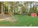 Spacious backyard featuring a playground, trampoline, storage shed, and mature trees at 151 Quail Hollow Dr, Dallas, GA 30157