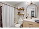 Cozy bathroom features a shower-tub combo, modern vanity, and rustic shelving at 151 Quail Hollow Dr, Dallas, GA 30157