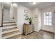 Inviting entryway with hardwood floors, staircase, and a decorative cabinet with a mirror at 151 Quail Hollow Dr, Dallas, GA 30157
