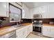 Well-lit kitchen featuring white cabinets, stainless steel appliances, and wood countertops at 151 Quail Hollow Dr, Dallas, GA 30157