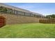 The grassy backyard has a retaining wall and wooden fence, offering a private outdoor space at 1637 Short Shadow Ln, Snellville, GA 30078