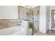 Bathroom boasts a tiled shower with a glass enclosure and a large soaking tub at 1637 Short Shadow Ln, Snellville, GA 30078
