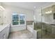 Elegant bathroom features dual vanity, soaking tub, and separate glass enclosed shower at 1637 Short Shadow Ln, Snellville, GA 30078
