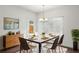Dining room with a table and chairs, a cabinet, large windows, and a modern chandelier at 1637 Short Shadow Ln, Snellville, GA 30078