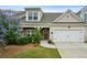 Charming home featuring a two-car garage, stone accents, and a beautifully landscaped front yard at 1637 Short Shadow Ln, Snellville, GA 30078