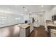Open-concept kitchen with stainless steel appliances, island, and seamless access to the living room at 1637 Short Shadow Ln, Snellville, GA 30078