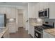 Well-lit kitchen features stainless steel appliances, granite countertops, gray backsplash, and ample cabinet space at 1637 Short Shadow Ln, Snellville, GA 30078