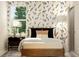 Sunlit bedroom with nature-themed wallpaper, a cozy bed, and stylish decor creating a serene and inviting space at 1924 Logan Se Ln, Conyers, GA 30094