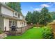 Spacious backyard featuring a wooden deck, lush lawn, and mature trees at 200 Creek Run Ct, Alpharetta, GA 30005