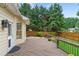 Wooden deck features outdoor lighting with fenced backyard and luscious greenery at 200 Creek Run Ct, Alpharetta, GA 30005