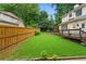 Expansive backyard with a wooden fence, deck, and luscious greenery and landscaping at 200 Creek Run Ct, Alpharetta, GA 30005
