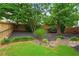 Landscaped backyard with rock features, mulch, and green lawn at 200 Creek Run Ct, Alpharetta, GA 30005