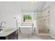 Bathroom showing the tiled shower, chrome fixtures, and soaking tub beneath a window at 200 Creek Run Ct, Alpharetta, GA 30005