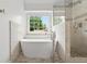 Bright bathroom featuring a soaking tub, chrome fixtures, and a tiled stand-up shower at 200 Creek Run Ct, Alpharetta, GA 30005