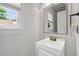 Powder room with a classic design featuring a vanity with a mirror, a window, and traditional fixtures at 200 Creek Run Ct, Alpharetta, GA 30005
