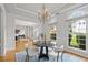 Bright dining room featuring a modern chandelier, a table set for four, and large windows providing natural light at 200 Creek Run Ct, Alpharetta, GA 30005