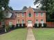 Inviting two-story brick home boasts symmetrical windows, a gabled roof, and a neatly landscaped front yard at 200 Creek Run Ct, Alpharetta, GA 30005