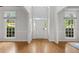 Bright and open foyer featuring hardwood floors, a white front door, and large windows providing natural light at 200 Creek Run Ct, Alpharetta, GA 30005