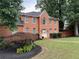 Charming two-story red brick home with a beautifully landscaped front yard and a welcoming front door at 200 Creek Run Ct, Alpharetta, GA 30005