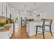 Bright kitchen featuring white cabinets, stainless steel appliances, breakfast bar, and hardwood flooring at 200 Creek Run Ct, Alpharetta, GA 30005