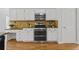 Kitchen with a stainless steel range, microwave, white cabinets, and hardwood floors at 200 Creek Run Ct, Alpharetta, GA 30005