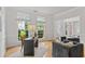 Well-lit home office with hardwood floors, large windows, and a comfortable seating area, creating a functional workspace at 200 Creek Run Ct, Alpharetta, GA 30005