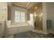 Bright bathroom features a soaking tub with jets under a window and separate glass-enclosed shower at 3071 Intrepid Wake, Marietta, GA 30062