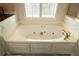 Close-up view of a soaking tub with jets under a window with plantation shutters at 3071 Intrepid Wake, Marietta, GA 30062