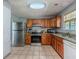Functional kitchen featuring wooden cabinets, granite countertops, and stainless-steel appliances at 4728 Garden Hills Dr, Stone Mountain, GA 30083