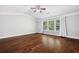 Spacious bedroom features wood floors, a ceiling fan, and a large window for natural light at 1220 Roswell Manor Cir, Roswell, GA 30076
