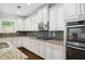 Bright kitchen features white cabinets, granite countertops, stainless appliances, and tile backsplash at 1220 Roswell Manor Cir, Roswell, GA 30076