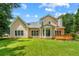 A spacious backyard with lush green grass and mature trees surrounding the property and house at 1995 Settindown Dr, Roswell, GA 30075