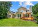 Backyard view showcasing the house with a deck, sunroom, and a well-manicured lawn at 1995 Settindown Dr, Roswell, GA 30075