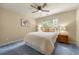 Cozy bedroom with blue carpet, ceiling fan, and a window with natural light at 1995 Settindown Dr, Roswell, GA 30075