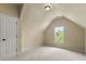 Attic bedroom with neutral carpet, door to the left, and natural light from the window at 1995 Settindown Dr, Roswell, GA 30075