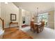 Elegant dining area with modern lighting fixture, view to front entry, and large picture window at 1995 Settindown Dr, Roswell, GA 30075